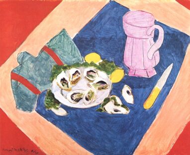 Still life: plate of oysters with lemon wedges and greens on a blue placemat, beside a pink pitcher and knife.