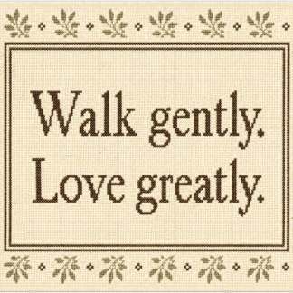 Cross-stitch sampler on beige fabric with a decorative green border; inside, the text reads “Walk gently. Love greatly.” framed by a double brown border.
